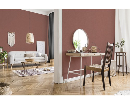 Wohnzimmer mit gemusterter Tapete, Sofa, Tisch und Dekorationen für ein gemütliches Ambiente.