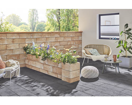 Gestalteter Aussenbereich mit Mauer, Pflanzkästen, Sitzgelegenheiten und Bodenbelag.