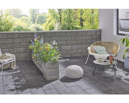 Gestalteter Aussenbereich mit Pflastersteinen, Mauer und Sitzgelegenheiten