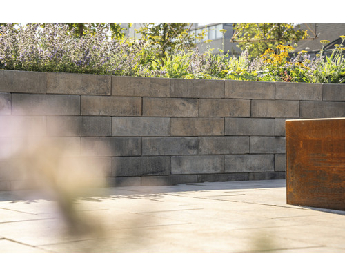 Un mur de jardin en blocs de béton planté de fleurs