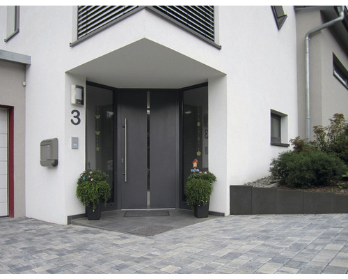 Zone d''entrée d''une maison avec porte d''entrée grise, numéro de maison et bacs à plantes