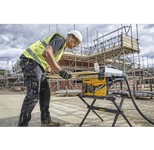 Un ouvrier du bâtiment utilise une scie circulaire de table sur un chantier.