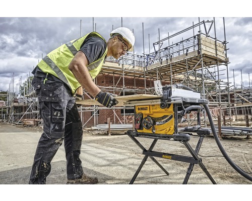 Un ouvrier du bâtiment utilise une scie circulaire de table sur un chantier.