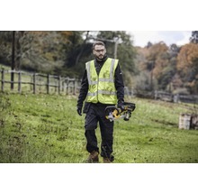 Homme avec gilet de sécurité et tronçonneuse à batterie à l''extérieur