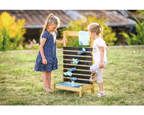 Zwei Kinder spielen mit einer Wasserspielbahn im Garten.