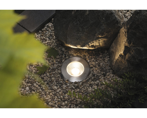 Bodeneinbaustrahler im Garten zwischen Steinen und Kies