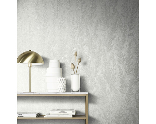 Décoration murale avec papier peint structuré à motif végétal, table avec décoration et lampe