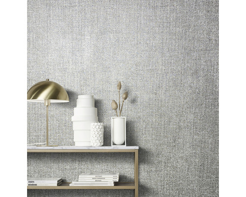 Nahaufnahme einer Wand mit Textiltapete und einem Tisch mit Dekoration