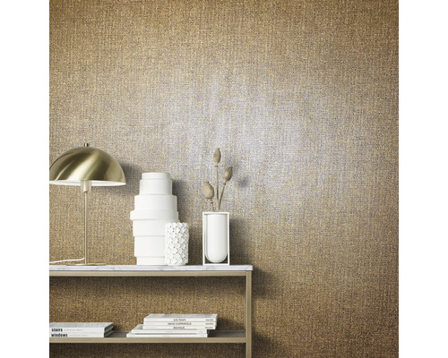 Nahaufnahme einer goldfarbenen Textiltapete mit Tisch, Lampe und Dekoration