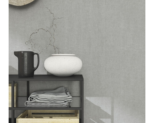 Dekorative Gegenstände auf einem Regal mit Stoffen und Holzkisten