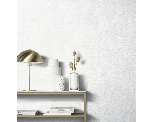 Helle Tapete mit Stoffstruktur im Wohnraum mit Tisch und Dekorationsgegenständen.