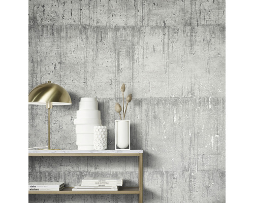 Scène avec un papier peint gris aspect béton, une lampe dorée et des objets décoratifs sur une étagère