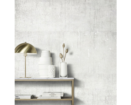 Pièce décorative avec lampe, vases et livres sur une table devant un mur texturé