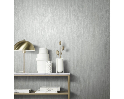 Gros plan d''un papier peint argenté avec un motif à rayures verticales dans une pièce lumineuse.