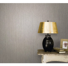 Nahaufnahme einer Wand mit Vliestapete und einer Lampe auf einem Tisch
