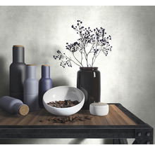 Dekorative Anordnung mit Flaschen, Schale, Samen und Vase auf einem Tisch