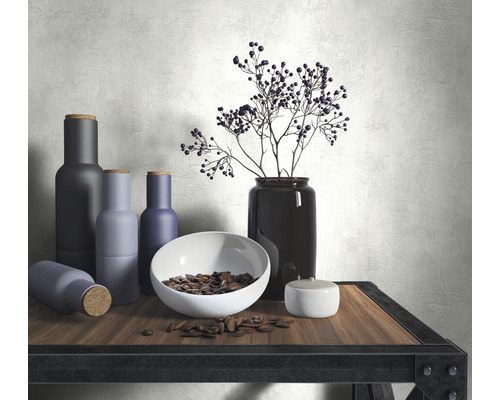 Arrangement décoratif avec bouteilles, bol, graines et vase sur une table
