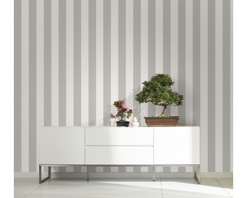 Raumansicht mit gestreifter Tapete, Sideboard und Bonsai-Bäumen