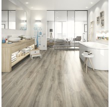 Salle de bain lumineuse avec lavabo, baignoire et sol stratifié imitation bois