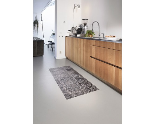 Einrichtungsszene mit Küchenzeile mit Holzfronten, Küchenarmatur, Kaffeemaschine und einem gemusterten Teppich auf dem Boden