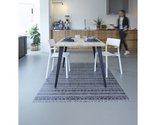 Esszimmer mit Holztisch, weißen Stühlen und gemustertem Teppich