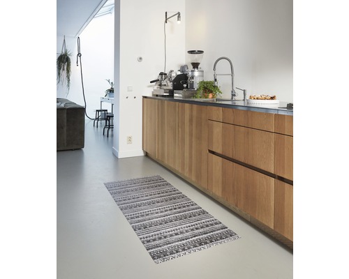 Cuisine avec armoires en bois et un tapis à motifs