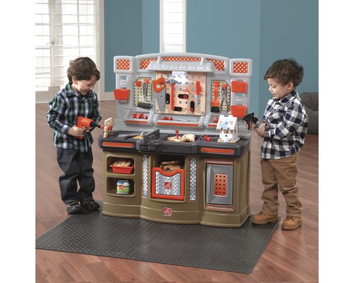 Spielzeugwerkbank mit zwei spielenden Kindern.