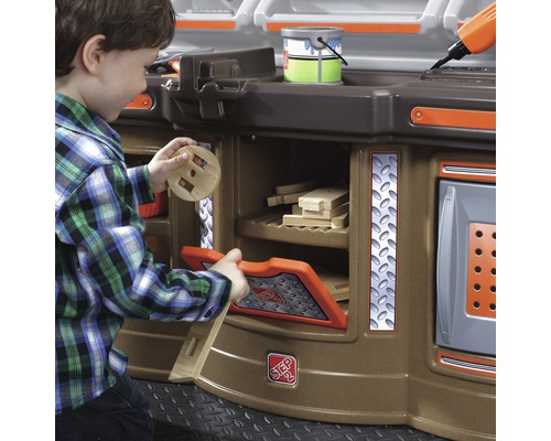 Junge spielt mit einer Werkbank für Kinder mit Aufbewahrung