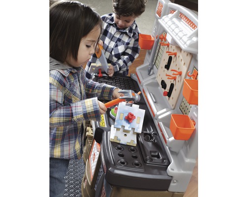 Zwei Kinder spielen mit einer Werkbank und Werkzeugen