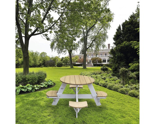 Runder Picknicktisch aus Holz mit Bänken im Garten.