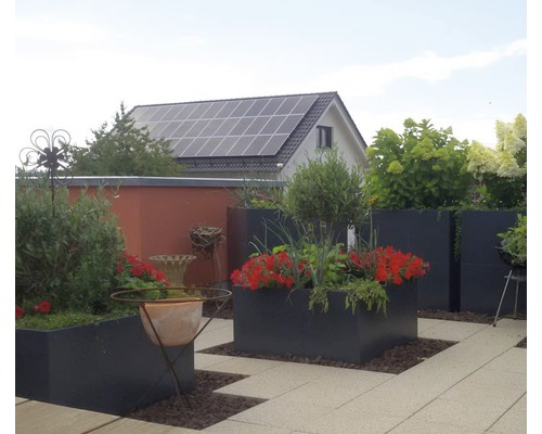 Terrasse avec jardinières plantées, cabane de jardin et installation photovoltaïque sur le toit