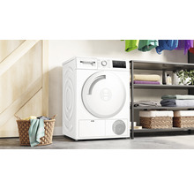 Sèche-linge à pose libre Bosch dans la buanderie avec panier à linge et étagère