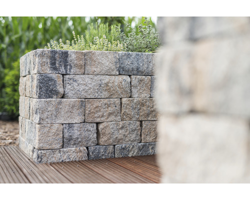 Mur de soutènement en blocs de pierre avec des plantes dessus sur terrasse en bois