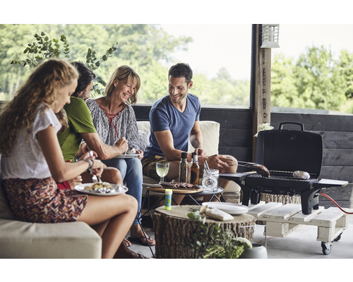 Un groupe de personnes fait un barbecue ensemble à l''extérieur avec un barbecue portable.