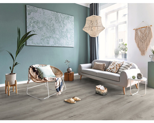 Espace de vie lumineux avec canapé, fauteuil, décoration et revêtement de sol gris