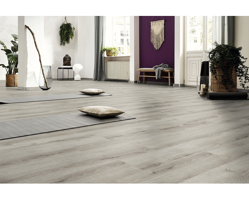 Pièce lumineuse avec plancher en bois gris, tapis de yoga et coussins