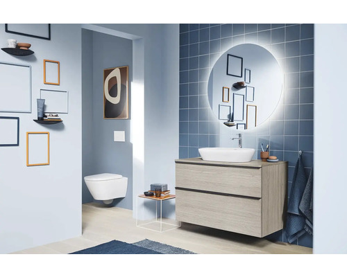 Salle de bain moderne avec lavabo, miroir et toilettes au design clair