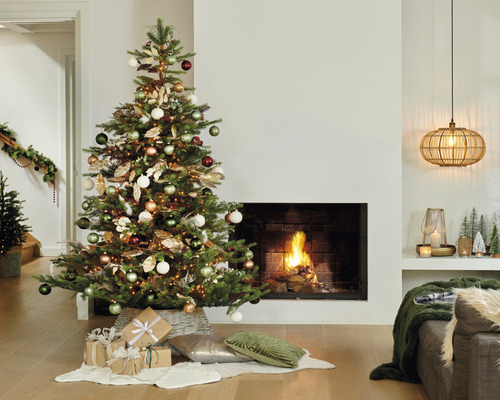 Festlich geschmückter Weihnachtsbaum in einem Wohnzimmer mit Kamin.