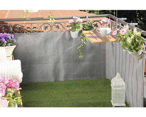 Balcon aménagé avec un tapis brise-vue, des plantes et de la décoration