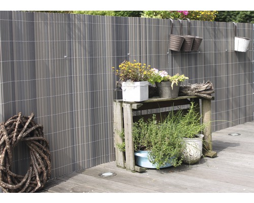 Sichtschutzzaun mit Pflanzen und Dekoration im Garten