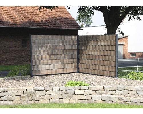 Clôture d''intimité avec surface en forme de bardeau dans le jardin