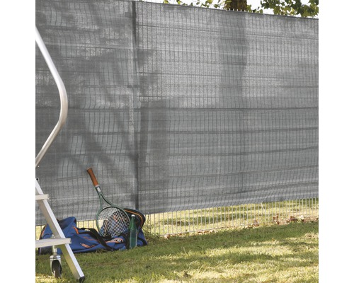 Sichtschutzzaun mit Tenniszubehör auf Rasenfläche