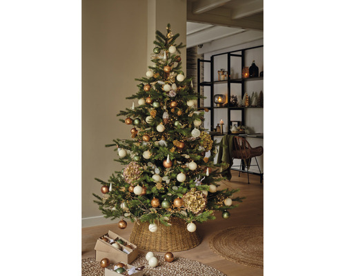 Sapin de Noël décoré avec des boules de Noël et des lumières dans le salon.