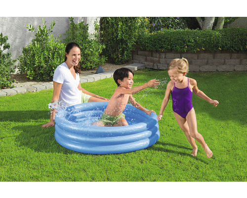 Szene mit Kindern, die in einem aufblasbaren Planschbecken im Garten spielen