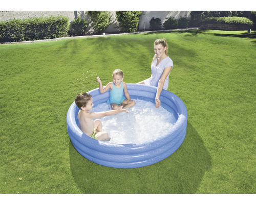 Aufblasbarer Pool mit spielenden Kindern und einer Frau im Garten
