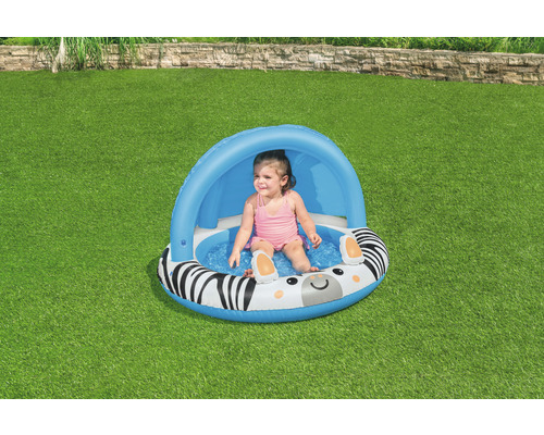 Kind sitzt in aufblasbarem Planschbecken mit Zebra Design und Sonnenschutz