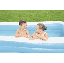 Zwei Kinder spielen in einem aufblasbaren Schwimmbecken im Garten.