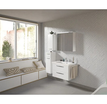 Badezimmer mit Waschtisch, Spiegelschrank, Hochschrank, Fensterbank mit Kissen und Fliesenwand in Fischgrätmuster
