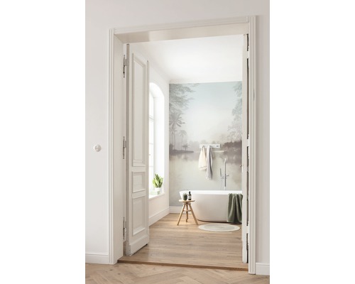 Salle de bains avec baignoire, plancher en bois et peinture murale à travers la porte ouverte