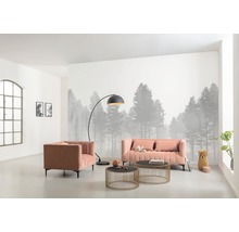 Wohnzimmer mit Sofa, Sessel, Stehlampe und Couchtischen vor einer Fototapete mit Waldmotiv.